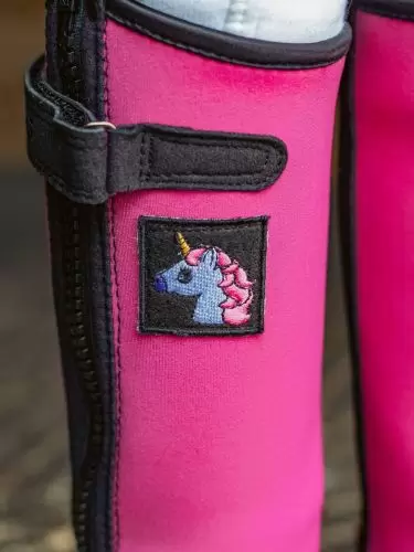A close up of child half chaps for kids in pink with a unicorn motif by Just Chaps