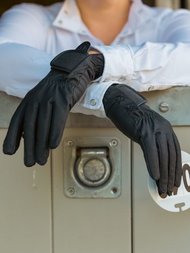 Horse rider standing by stable door wearing a pair of Competition gloves in black by Just Chaps