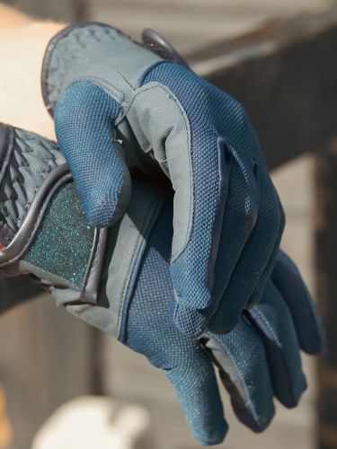 Horse rider wearing a pair of Summer-Weight Horse Riding Gloves in navy by Just Chaps