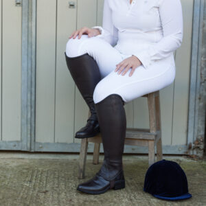Wide chaps for wide legs worn by lady rider sat outside of the stable