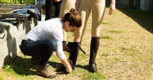 Just Chaps staff member helping lady rider find the perfect fit half chaps